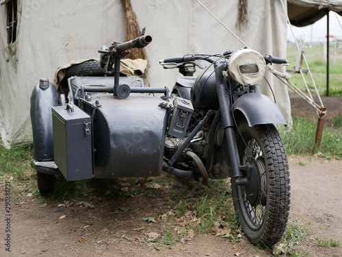World war II motorcycle with sidecar and mounted ammunition boxes and mg-42 machine gun. German military motorcycle painted in dark gray. Vintage motorcycles. Camouflage. Reconstruction of military eq