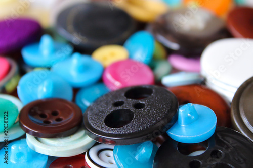 Old multi-colored plastic buttons for clothes. Close-up. Top view. Background. Texture.
