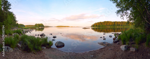 On the shore of lake Ladoga in the evening with a reflection in the water . Ladoga Skerries, Karelia.