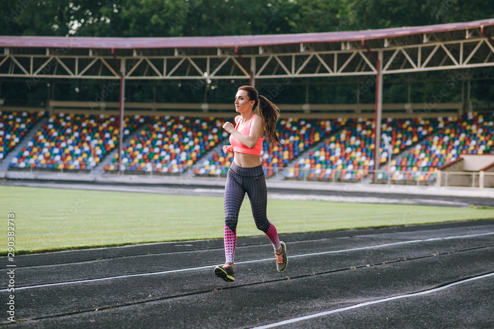 Fototapeta premium beautiful girl sporting appearance running. Girl running on sunset background