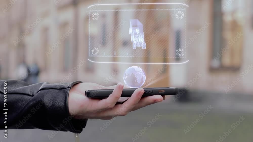 Male hands show on smartphone conceptual HUD hologram Americam Truck. Man with the future technology mobile holographic screen on blurred background of the university