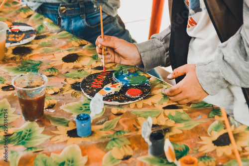 hand with a brush painting ceramic figure