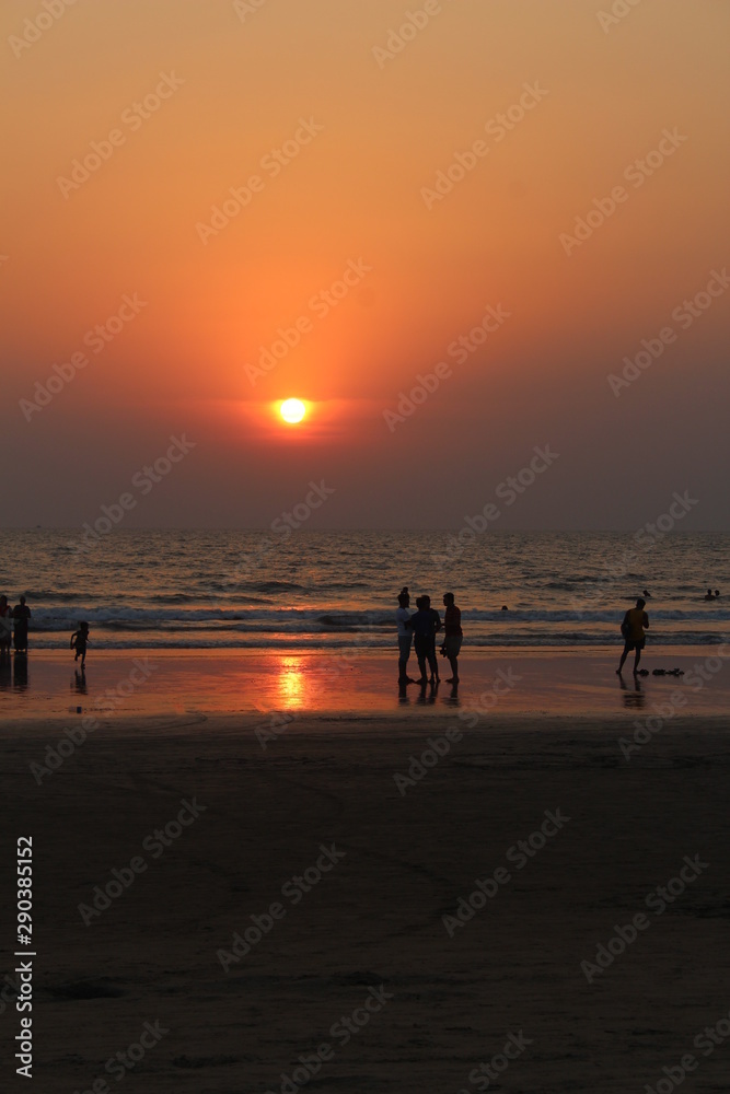 people on the background of an orange sunset in GOA