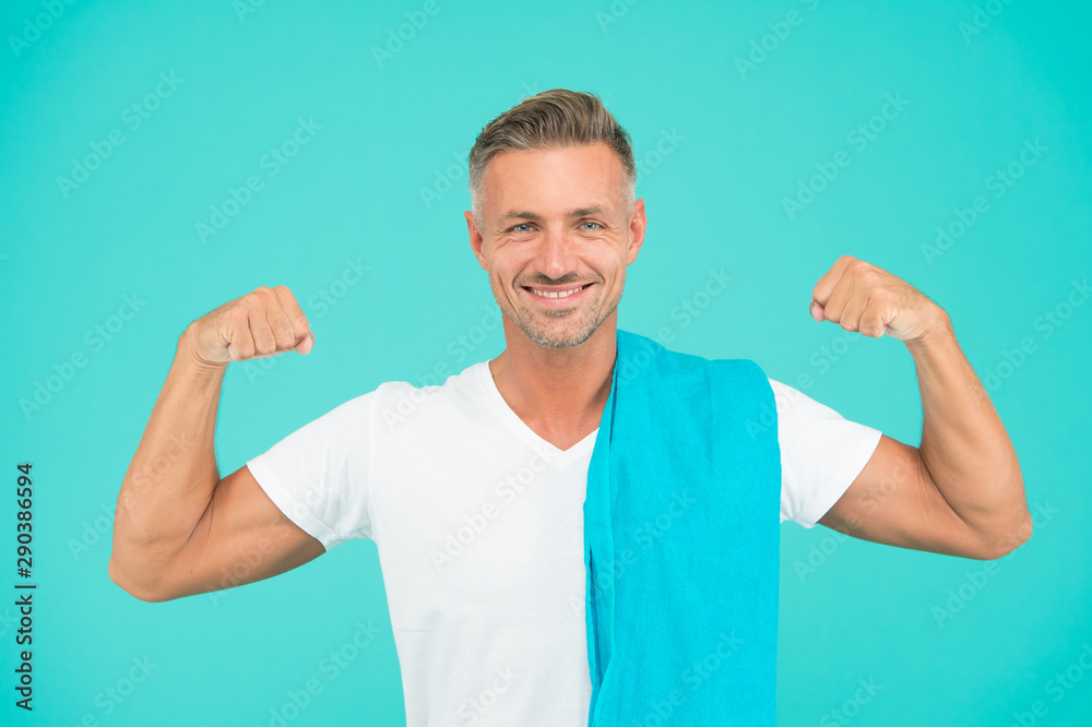 Healthy lifestyle. Gym wear and sports fashion for men. Gym aesthetics. Man well groomed athlete with towel on blue background. Mature but still in good shape. Exercising in gym for better health Healthy lifestyle. Gym wear and sports fashion for men. Gym aesthetics. Man well groomed athlete with towel on blue background. Mature but still in good shape. Exercising in gym for better health