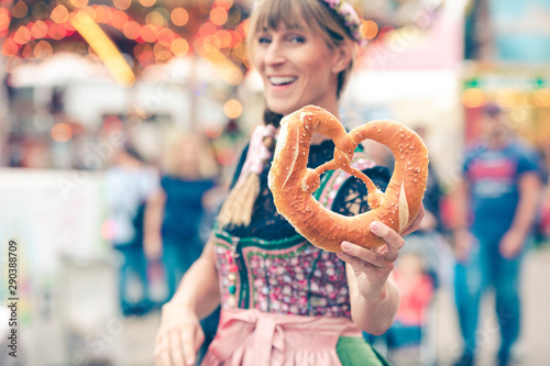 Junge Frau auf der Dult Oktoberfest hält Brezel