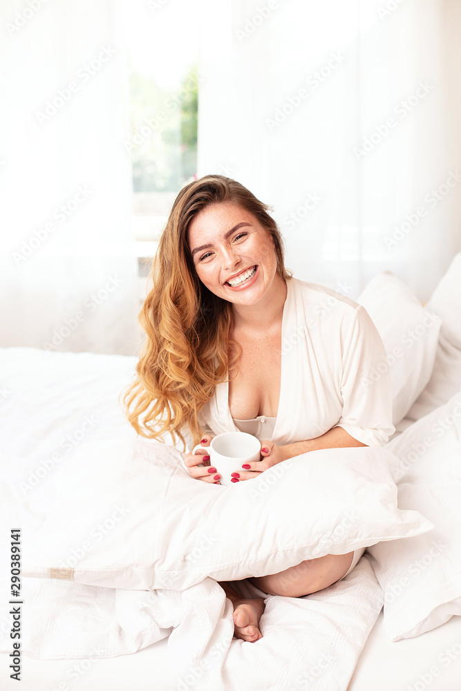 Happy ginger girl smiling, relaxing in bed. Happy ginger girl smiling, relaxing in bed.