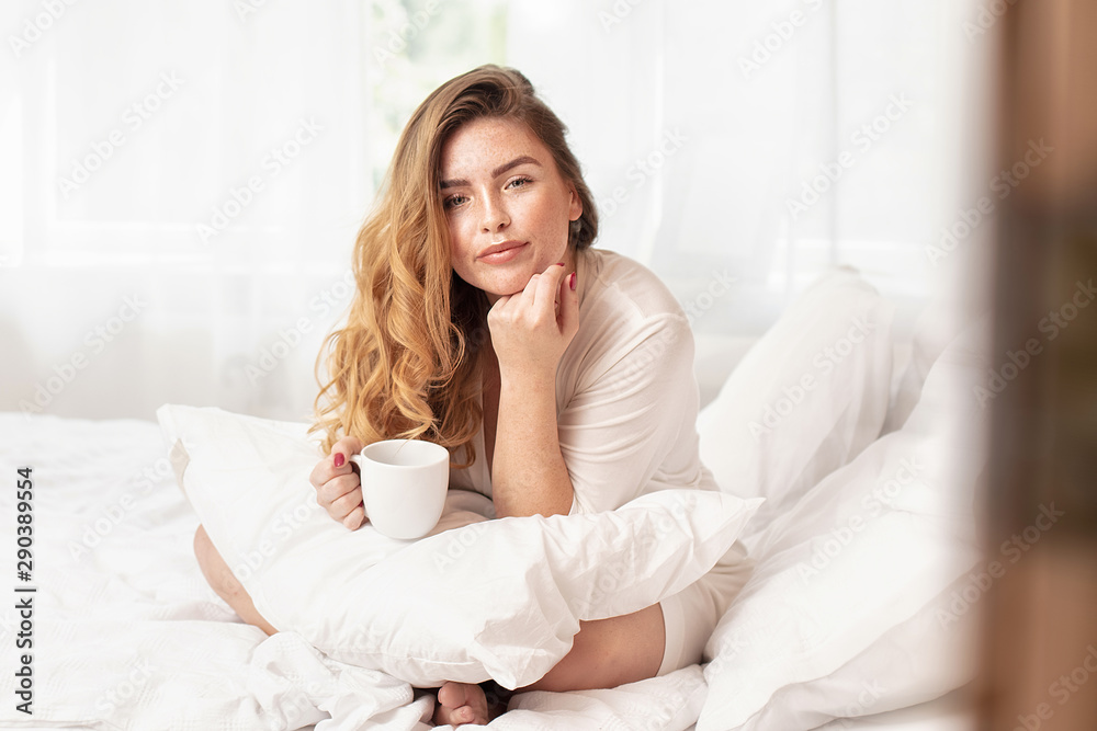 Happy ginger girl smiling, relaxing in bed. Happy ginger girl smiling, relaxing in bed.