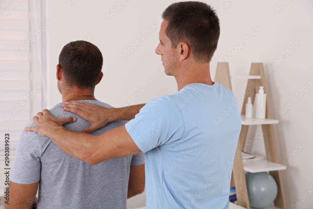 Obraz premium Chiropractic treatment, Back pain relief. Physiotherapy / Kinesiology for male patient, sport injury recovery
