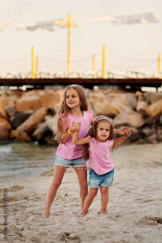 two little sisters having fun at the beach photo