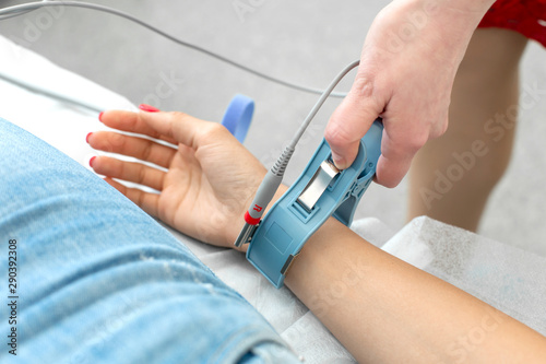 The therapist connects the electrocardiograph sensors to the patient s hand