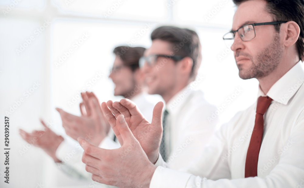 group of business people applauding sitting at the office table. group of business people applauding sitting at the office table.