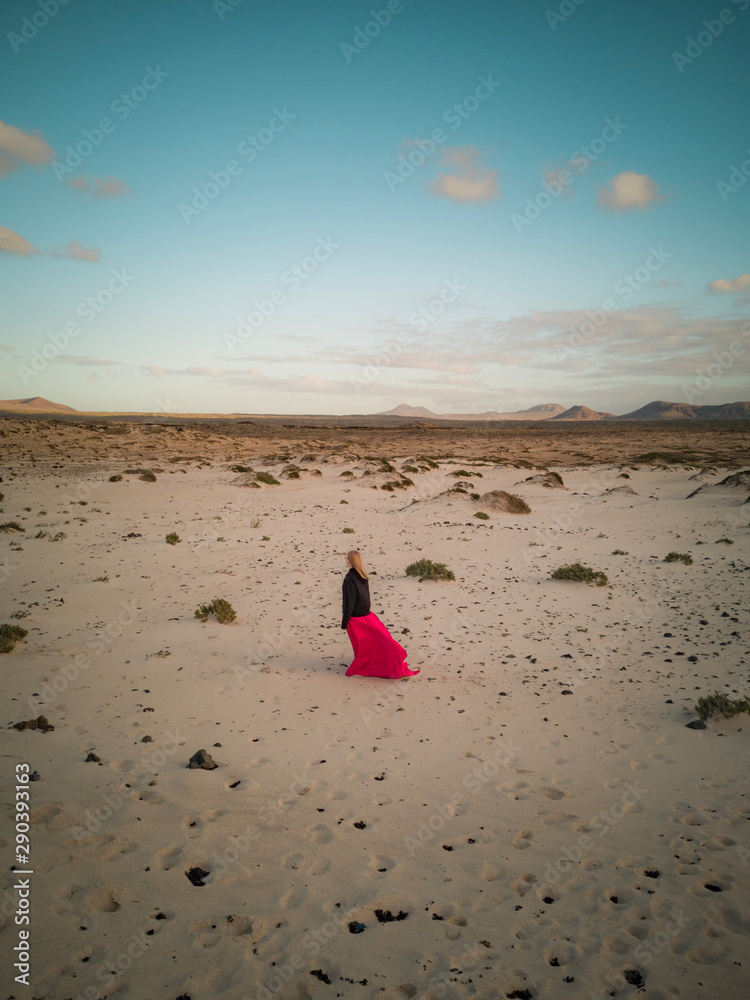 woman walking on beach at sunset