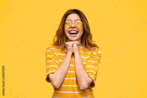 Delighted stylish woman clasping hands