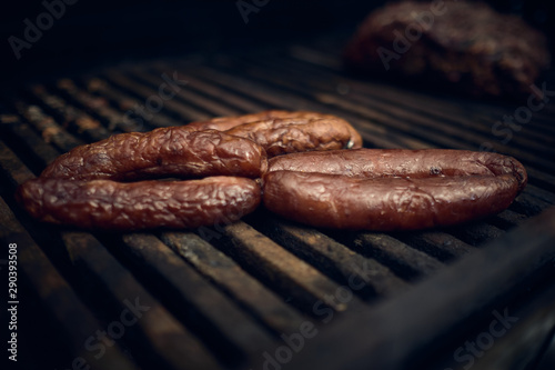 Grilled chorizo sausage over the barbecue fire. You can see the smoke, the fire and the heat as well as the fiery ones of the melted fats when falling under the direct fire