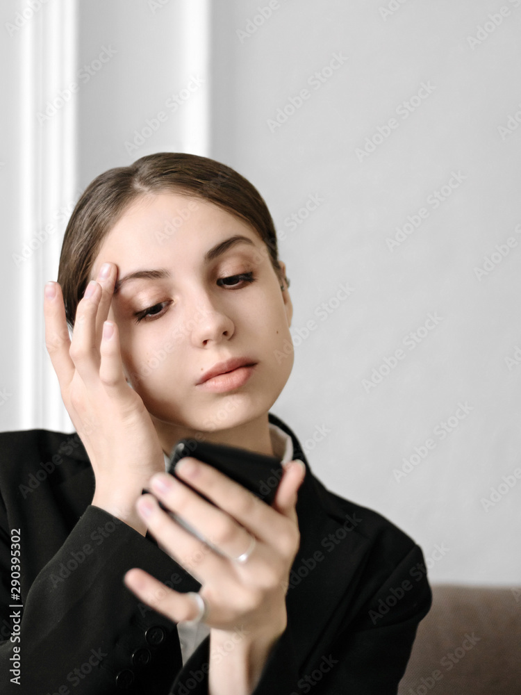 Waiting job interview Young woman in a business suit is correcting makeup while looking in mirror Waiting job interview Young woman in a business suit is correcting makeup while looking in mirror