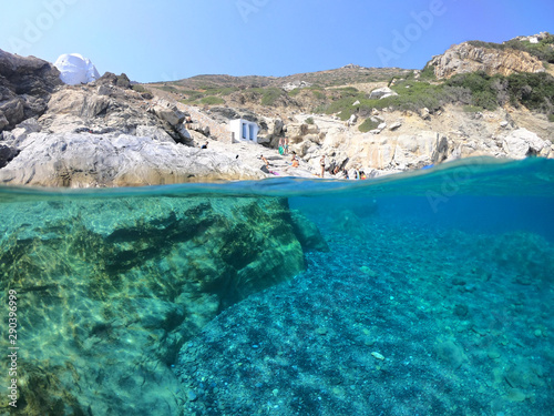 Above and below underwater photo of crystal clear sea paradise rocky seascape and small chapel of Agia Anna just next to iconic Hozoviotissa Monastery  Amorgos island  Cyclades  Greece