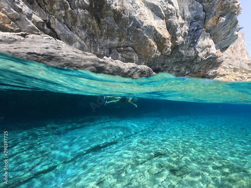 Above and below underwater photo of crystal clear sea paradise rocky seascape and small chapel of Agia Anna just next to iconic Hozoviotissa Monastery, Amorgos island, Cyclades, Greece