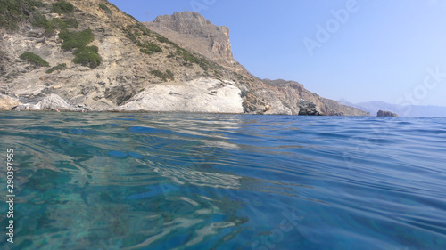 Above and below underwater photo of crystal clear sea paradise rocky seascape and small chapel of Agia Anna just next to iconic Hozoviotissa Monastery, Amorgos island, Cyclades, Greece photo