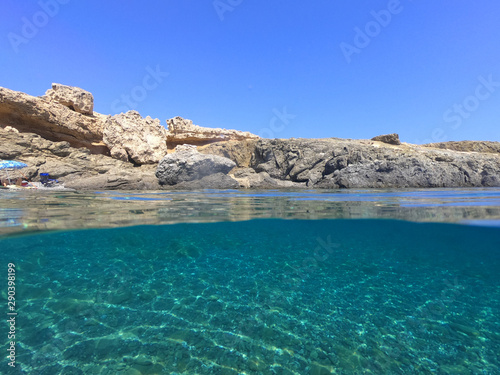 Above and below underwater photo of crystal clear turquoise beach of Kaminakia, Astypalaia island, Dodecanese, Greece
