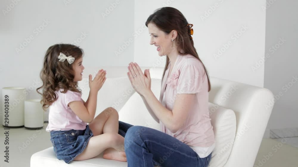Caucasian mother and daughter clapping hands Caucasian mother and daughter clapping hands