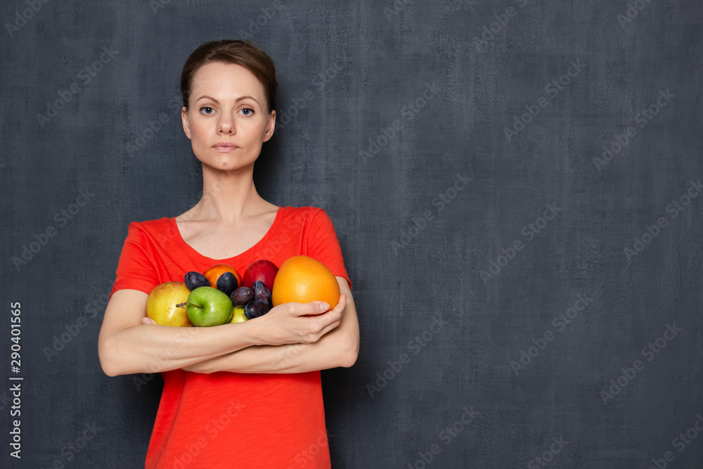 Portrait of serious woman holding ripe fresh fruits in hands Portrait of serious woman holding ripe fresh fruits in hands