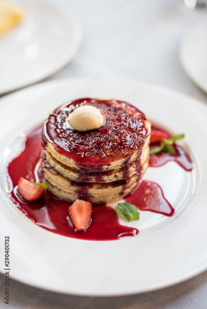 Pancakes with berry sauce and fresh strawberries. Brunch in restaurant Pancakes with berry sauce and fresh strawberries. Brunch in restaurant