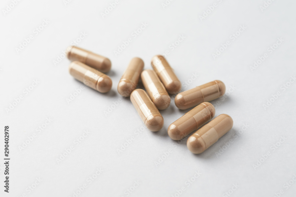Reishi Mushroom capsules. Concept for a healthy dietary supplementation. White background. Close up. Copy space. Reishi Mushroom capsules. Concept for a healthy dietary supplementation. White background. Close up. Copy space.