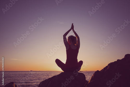 Fototapeta Naklejka Na Ścianę i Meble -  Silhouette of yoga woman on the seashore during sunset. Chrome photo.
