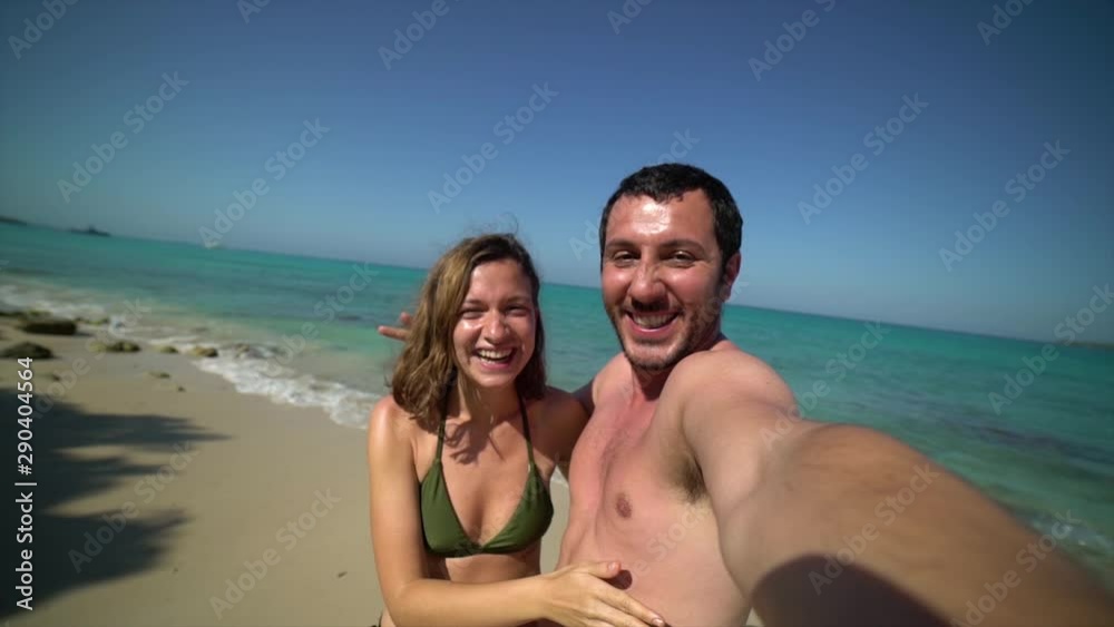 handsome cheerful young couple in love taking selfie on beach. Portrait of carefree tourists enjoying summer vacation. Happy couple perfect white sand beach on travel caribbean destination holidays. handsome cheerful young couple in love taking selfie on beach. Portrait of carefree tourists enjoying summer vacation. Happy couple perfect white sand beach on travel caribbean destination holidays.