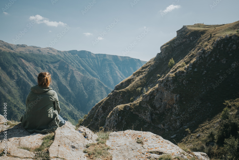 Girl sitting on the edge of the cliff