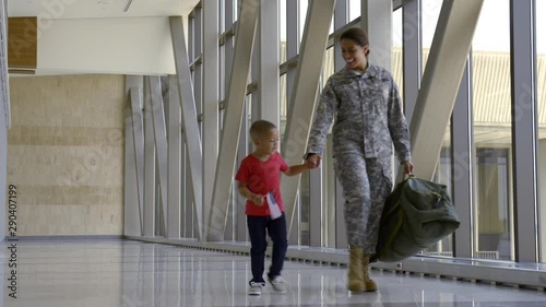 African American soldier and son walking in airport