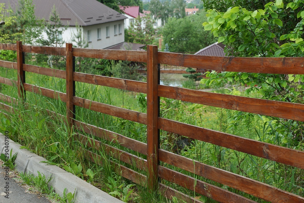 long rural fence of brown wooden planks outdoors in green grass long rural fence of brown wooden planks outdoors in green grass