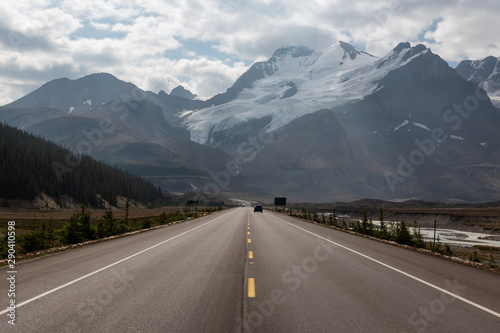 Scenic road in the Canadian Rockies during a vibrant sunny and cloudy summer morning. Taken in Icefields Parkway, Jasper National Park, Alberta, Canada.