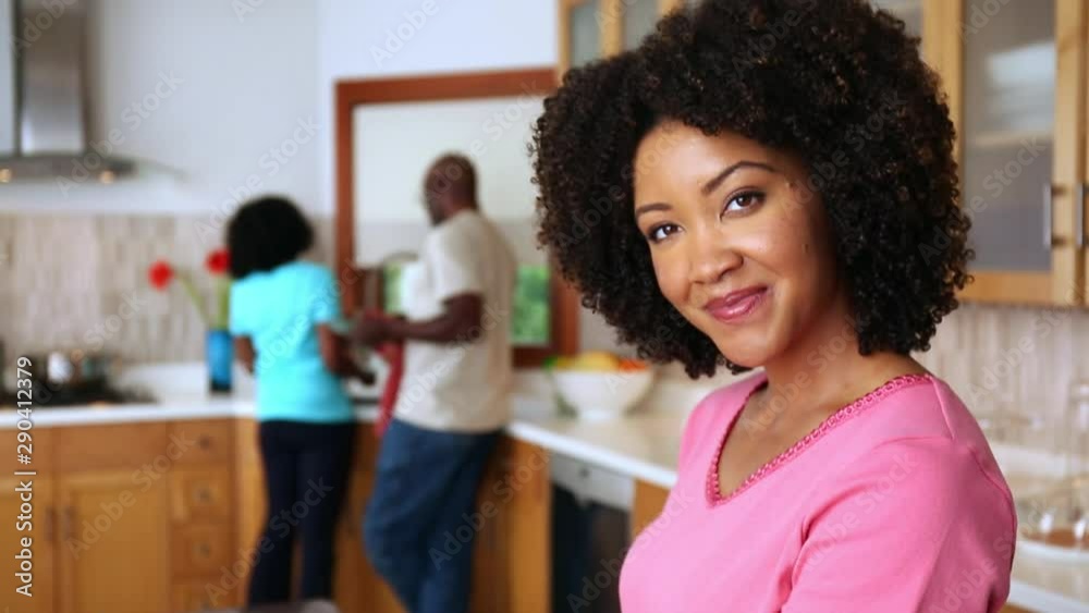 Smiling African American woman chopping tomato in domestic kitchen Smiling African American woman chopping tomato in domestic kitchen