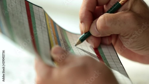 Hands of golfer writing on scorecard photo