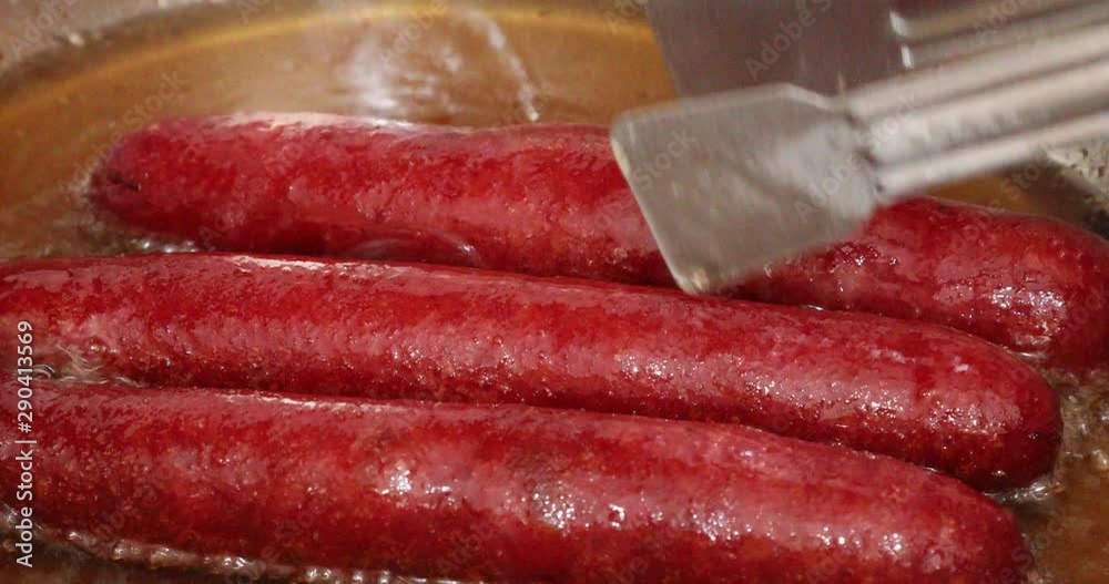 Delicious sausages frying in a pan Delicious sausages frying in a pan