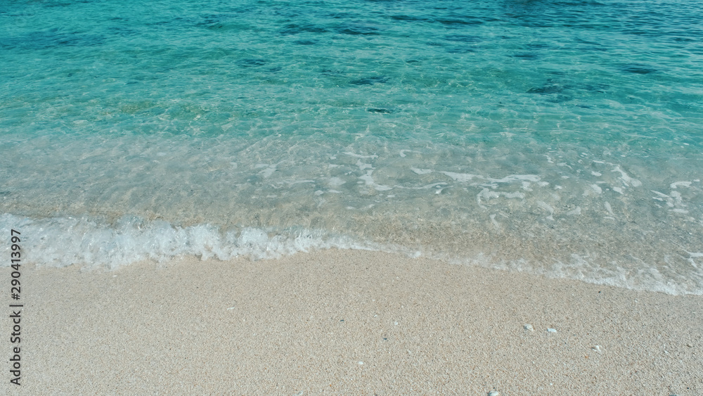 Emerald green water. Beautiful background transparent surface wave, sand on clean beach. Royalty high-quality free stock photo image of clean surface seawater, waves on the beach with sand in sunshine