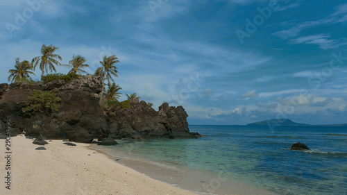 Deserted island, uninhabited island. Royalty high-quality stock photo image of desert island with palm tree, coconut trees on the beach, tropical beach clear turquoise water. Quiet, peaceful landscape