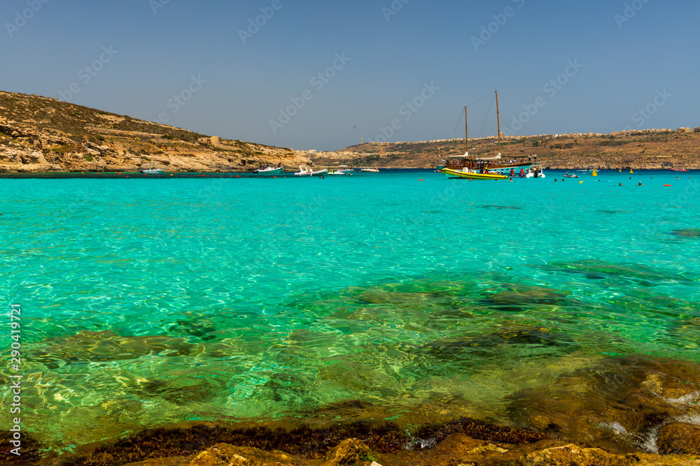 View of Blue Lagoon, located on Malta's smallest inhabited island Comino, with its clear turquoise shallow waters, golden rocks and dramatic coastline