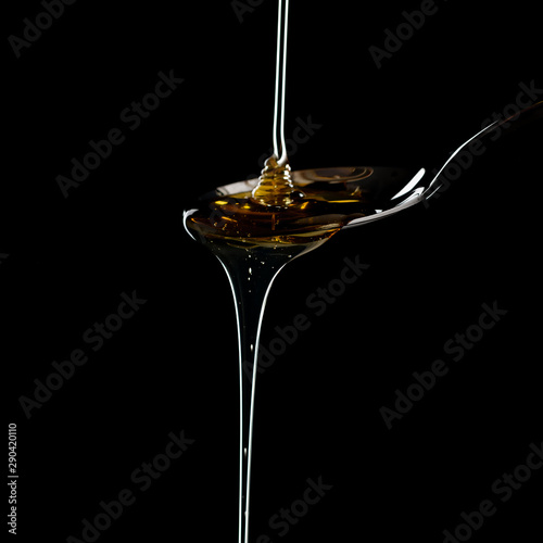 golden sweet honey dripping from spoon