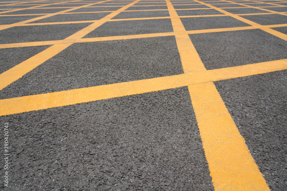 Low angle close-up of yellow asphalt cross grid on asphalt road Low angle close-up of yellow asphalt cross grid on asphalt road