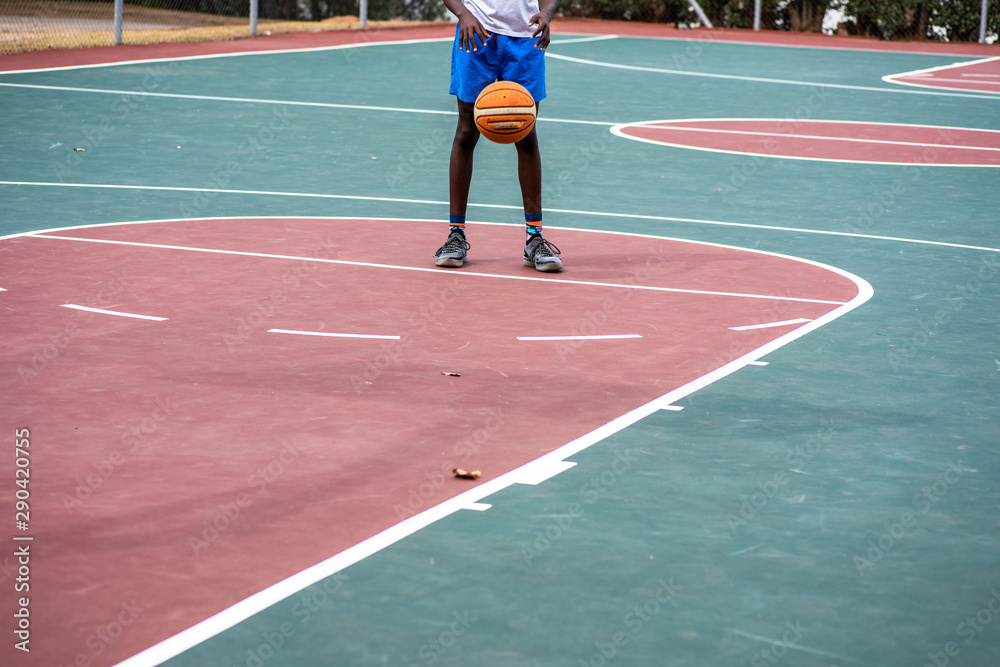 Young boy practicing his free throws on court