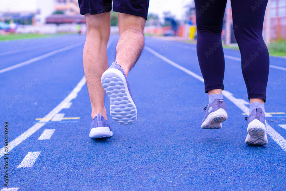 Closeup shoe. A couple jogging and walking together on the running track. Sport and exercise concept.