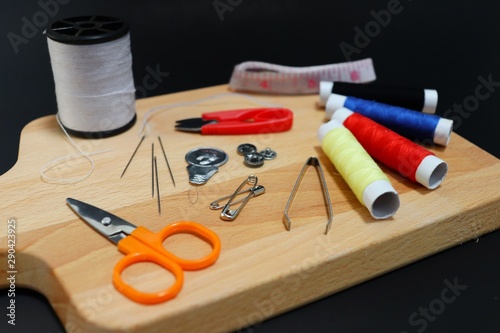 top view equipment for sewing about fashion designer on wooden , black background.
