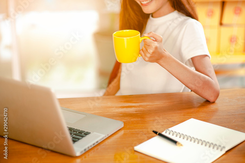 A woman using laptop device over a wooden workspace table for shopping online or Check the items that need to be shipped.Concept of shopping online business technology.