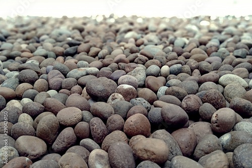 Closeup texture of a river pebble for background, low angle shot. 