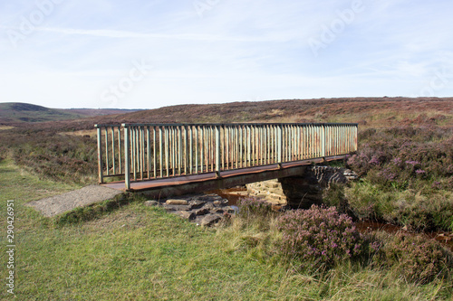 Old metal bridge crossing a moorland dales beck or stream