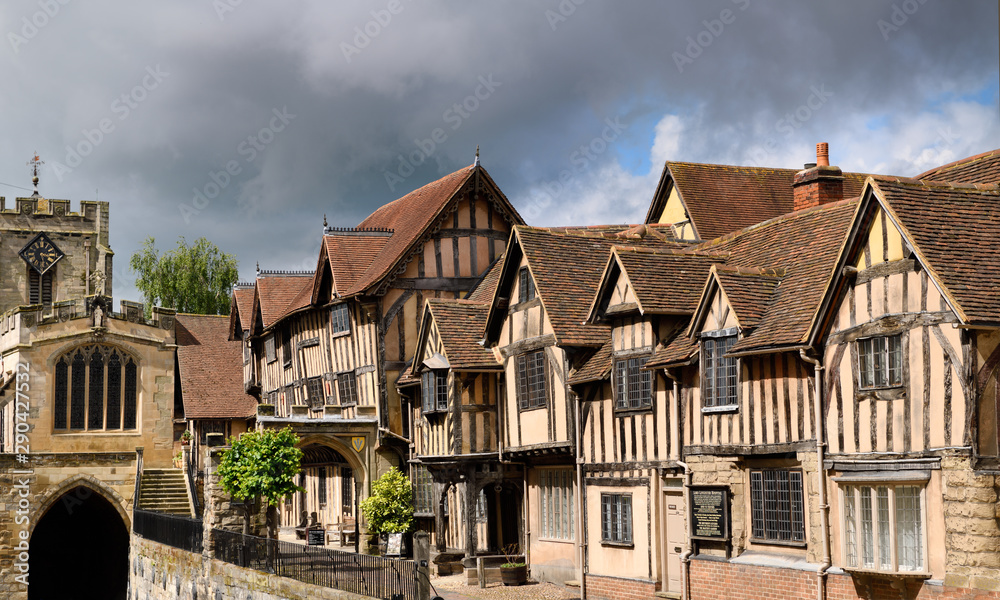 Crooked Medieval tudor houses of Lord Leycester Hospital for ex-servicemen at Chapel of St James over West Gate on High Street Warwick England