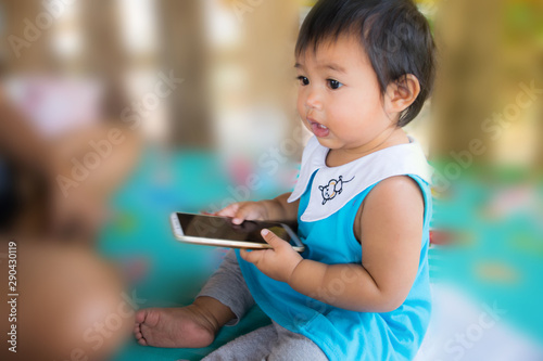 young child, a girl playing with a mobile phone, with his curiosity
