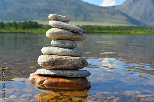 Stones meditation figures. Symbolical statue of several stones. Tradition to collect stones in private. Beautiful water landscape background with natural stones.